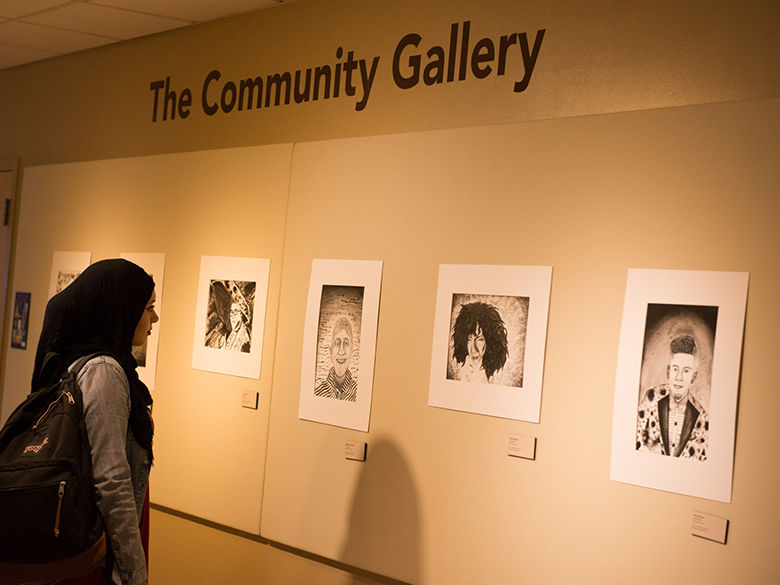 student viewing an exhibit in the community gallery